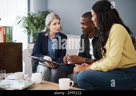 Siamo stati così felici che poteste vederci. una coppia che parla con un consulente finanziario a casa. Foto Stock