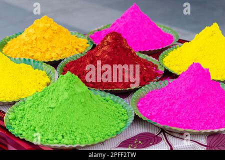 Mucchi di coloratissime vernici in polvere disposte in piatti durante il festival holi Foto Stock