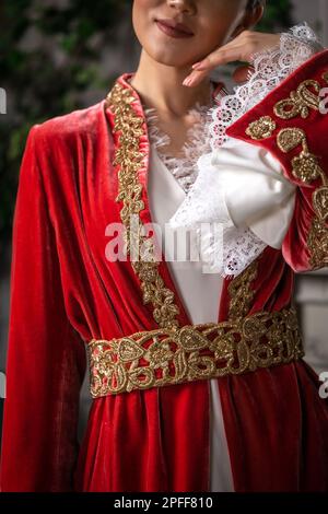 Una ragazza in un vestito nazionale kazako rosso su Nauryz. Foto Stock