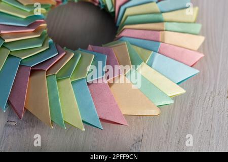 Origami ring, struttura parametrica astratta in fogli di carta colorati adagiato su una scrivania bianca Foto Stock