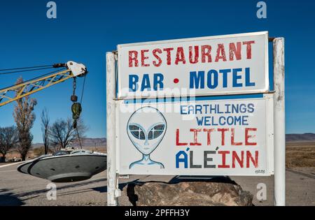 Si è schiantato UFO, appeso al braccio di un carro attrezzi, installazione locale d'arte, segno piccolo A’le’Inn motel, Extraterrestre Hwy NV-375, a Rachel, Grande Bacino Nevada Foto Stock