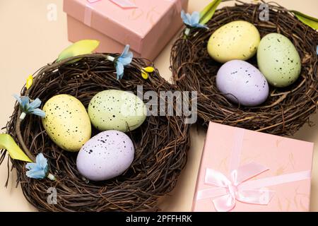 Regali per Pasqua, promozione di Pasqua. Uova in nidi e scatole regalo su sfondo beige Foto Stock