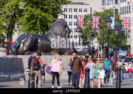 Londra, Regno Unito - 21 maggio 2018 : persone che camminano accanto ad uno dei Lions della famosa Trafalgar Square a Londra, Regno Unito Foto Stock