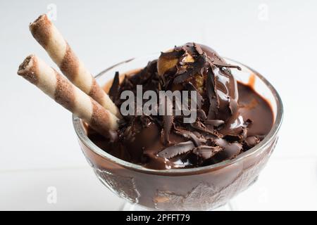 Deliziosi profiteroles con cioccolato, profiteroles su sfondo bianco isolato, primo piano. Foto Stock