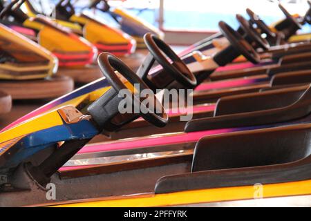 Le ruote sterzanti su una fila di divertenti auto Dodgem Fair. Foto Stock