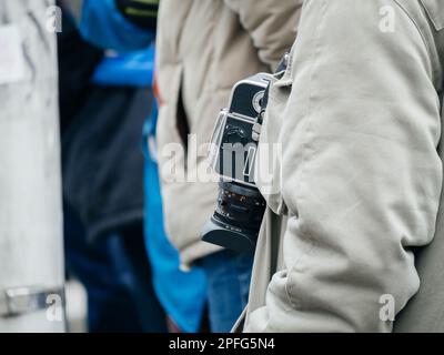 Strasburgo, Francia - 31 gennaio 2023: Uomo che indossa Hasselblad 503 cx 6x6 cm SLR trova a livello della vita intorno al collo nel centro della città Foto Stock