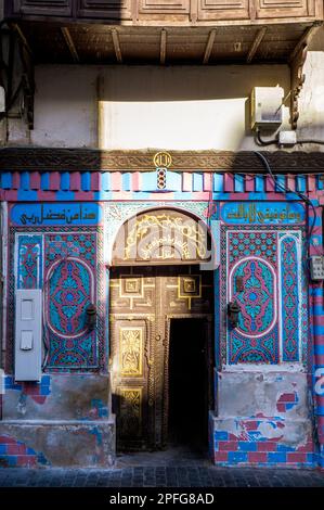 Vista di un bel portale ornato di una vecchia casa di corallo in al Layyat Ln Street, quartiere storico al-Balad a Jeddah, KSA, Arabia Saudita Foto Stock