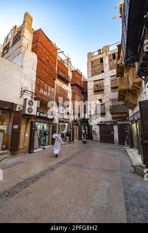 Vista di una piccola piazza circondata da alte e tradizionali case di corallo con negozi e negozi nella storica al-Balad a Jeddah, KSA, Arabia Saudita Foto Stock