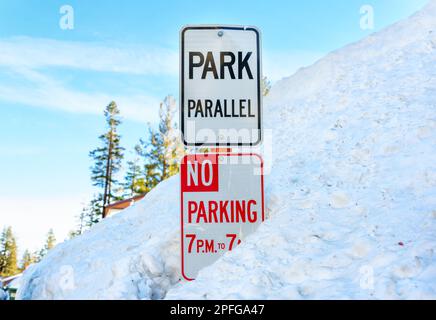 Sport invernali e sicurezza: Tempo di parcheggio e segnaletica parallela per il parcheggio in una profonda nevicata. Foto Stock