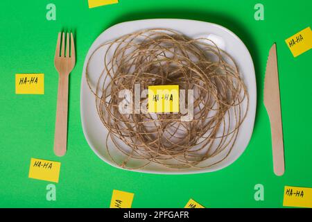 Un'immagine creativa delle battute del giorno degli sciocchi di aprile. Sostituire il cibo con articoli simili. Uso di forcelle e coltelli in legno. Le immagini di altri oggetti non sono ciò che Foto Stock