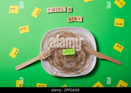 Un'immagine creativa delle battute del giorno degli sciocchi di aprile. Sostituire il cibo con articoli simili. Uso di forcelle e coltelli in legno. Le immagini di altri oggetti non sono ciò che Foto Stock