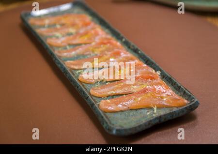 Deliziosi sashimi di salmone di prima qualità disposti su un elegante piatto fatto a mano. Foto Stock