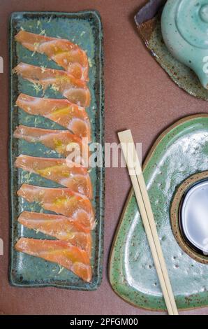 Deliziosi sashimi di salmone di prima qualità disposti su un elegante piatto fatto a mano. Foto Stock