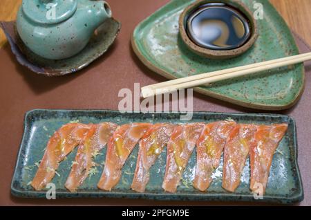 Deliziosi sashimi di salmone di prima qualità disposti su un elegante piatto fatto a mano. Foto Stock