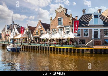 Lo yacht da diporto naviga attraverso l'accogliente e pittoresco villaggio di pescatori frisone Lemmer. Foto Stock