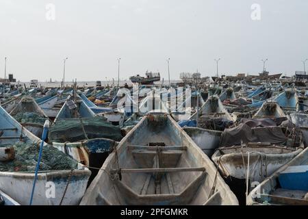 Un gruppo di vivaci barche da pesca blu e bianche a Nouadhibou, Mauritania, che catturano lo stile di vita e la tradizione marinara di questo villaggio costiero di pescatori Foto Stock