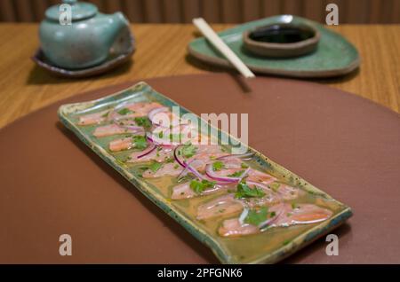 Deliziosi sashimi di salmone di prima qualità disposti su un elegante piatto fatto a mano. Foto Stock