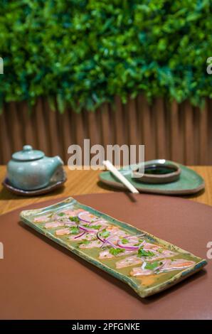 Deliziosi sashimi di salmone di prima qualità disposti su un elegante piatto fatto a mano. Foto Stock