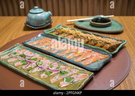 Deliziosi sashimi di salmone di prima qualità disposti su un elegante piatto fatto a mano. Foto Stock