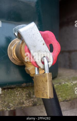 Lucchetto su un serbatoio diesel rosso in un cortile per prevenire i furti. North Yorkshire, Regno Unito. Foto Stock