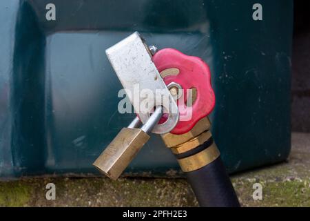 Lucchetto su un serbatoio diesel rosso in un cortile per prevenire i furti. North Yorkshire, Regno Unito. Foto Stock