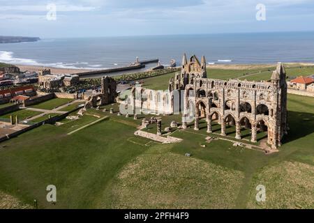 Una vista aerea del profilo delle rovine dell'Abbazia di Whiby sulla costa del North Yorkshire con l'oceano e la spiaggia visibili Foto Stock