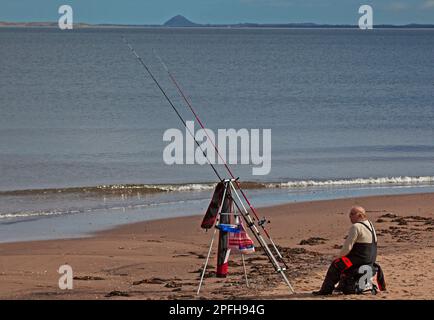 Portobello Beach, Edimburgo, Scozia, Regno Unito. 17 marzo 2023. Soleggiato e a 13 gradi centigradi per questo pescatore soleggiato con le sue linee nel Firth of Forth. Credit: Archwhite/alamy live news. Foto Stock