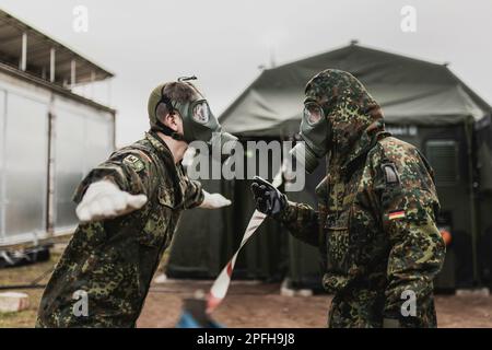 Due soldati di difesa della NBC in equipaggiamento protettivo, raffigurati durante la decontaminazione come parte di uno spettacolo di capacità presso la base delle forze armate della Bundeswehr a Mahlwinkel, 16 marzo 2023. Registrazione solo per uso editoriale! Foto Stock