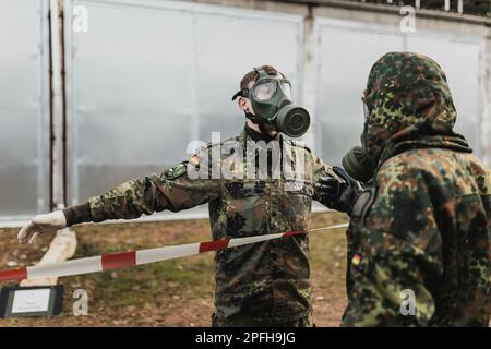 Due soldati di difesa della NBC in equipaggiamento protettivo, raffigurati durante la decontaminazione come parte di uno spettacolo di capacità presso la base delle forze armate della Bundeswehr a Mahlwinkel, 16 marzo 2023. Registrazione solo per uso editoriale! Foto Stock