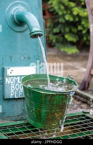 Secchio verde vecchio metallo secchio riempimento acqua beccuccio acqua dolce UKClean Foto Stock