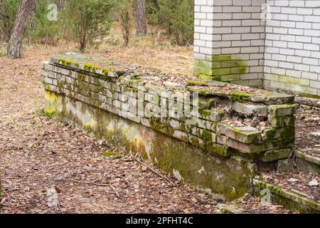 Distrutto muro di mattoni all'ingresso della terrazza di un edificio abbandonato e fatiscente, urbex. Foto Stock