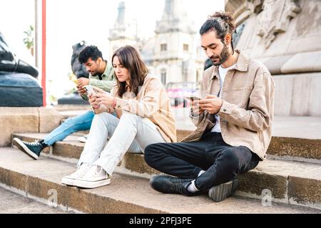 Vista laterale di ragazzi e ragazze che utilizzano smartphone - persone addicted dal telefono cellulare - concetto di stile di vita tecnologico con studenti sempre connessi Foto Stock