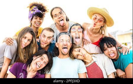 Multiculturale persone di età mista prendere selfie uscire lingua facendo volti divertenti - Crazy stile di vita e concetto di integrazione Foto Stock