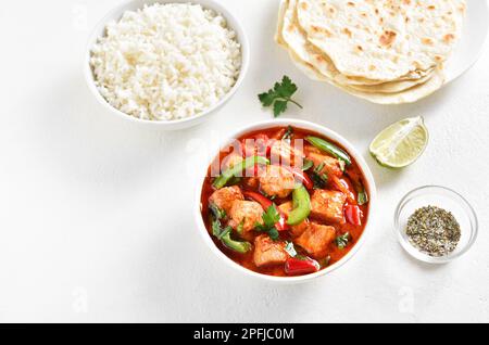 Curry di pollo rosso in stile tailandese con verdure in ciotola su sfondo bianco con spazio di testo libero. Foto Stock