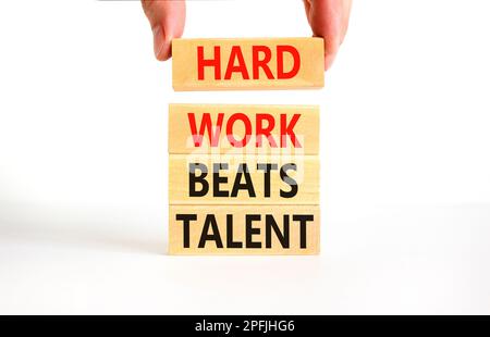Il duro lavoro batte il simbolo del talento. Concetto parole duro lavoro batte il talento su woodenblock. Bellissimo sfondo bianco tavolo. Business motivazionale difficile Foto Stock