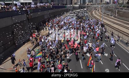 TEL AVIV, ISRAELE - MARZO 16: I manifestanti antigovernative detengono bandiere israeliane e il tradizionale orgoglio gay arcobaleno mentre bloccano l'autostrada Ayalon, una delle maggiori superstrade di Israele, durante una manifestazione contro la nuova coalizione di destra del primo ministro israeliano Benjamin Netanyahu e le sue proposte di cambiamento giudiziario. Il 16 marzo 2023 a Tel Aviv, Israele. Credit: Eddie Gerald/Alamy Live News Foto Stock