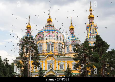 Colombe che volano sopra la Cattedrale dell'Ascensione o la Cattedrale di Zenkov, il Parco Panfilov, Almaty, Kazakistan, Asia Centrale Foto Stock