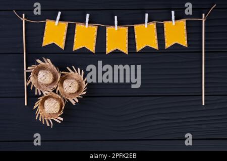 vestaglia con bandiere da festa e cappelli di paglia sul tavolo di legno. Foto Stock
