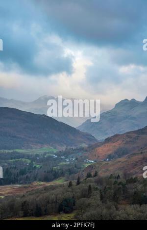 Splendida vista panoramica dell'alba invernale da Loughrigg cadde attraverso la campagna verso Langdale Pikes e Pike o'Blisco nel Lake District Foto Stock