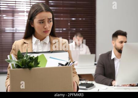 Sconvolto donna licenziato scatola di trasporto con personale roba in ufficio Foto Stock