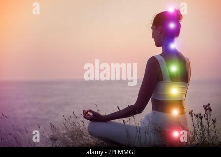 Donna meditante vicino al mare. Schema di sette chakra, illustrazione Foto Stock