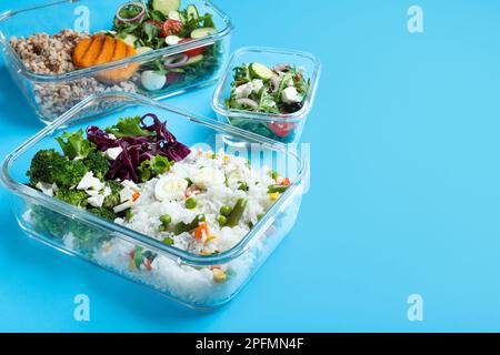 Set di contenitori di vetro con alimenti freschi su sfondo azzurro, spazio per testo Foto Stock