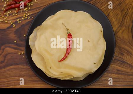 Papad, Khichiya papad, Rice papad, Chawal papad isolato su sfondo di legno. Foto Stock