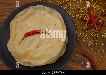 Papad, Khichiya papad, Rice papad, Chawal papad isolato su sfondo di legno. Foto Stock