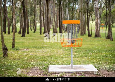 Disc golf (frolf) basket in un parco ostacolo campo con una profondità di campo poco profonda Foto Stock