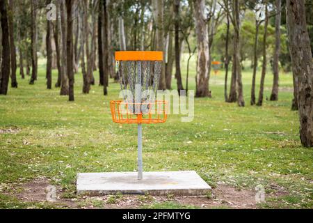 Disc golf (frolf) basket in un parco ostacolo campo con una profondità di campo poco profonda Foto Stock