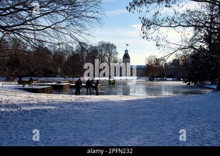 Karlsruhe, Germania - 12 febbraio 2021: Palazzo di Karlsruhe dietro uno stagno ghiacciato in una giornata invernale soleggiata in Germania. Foto Stock