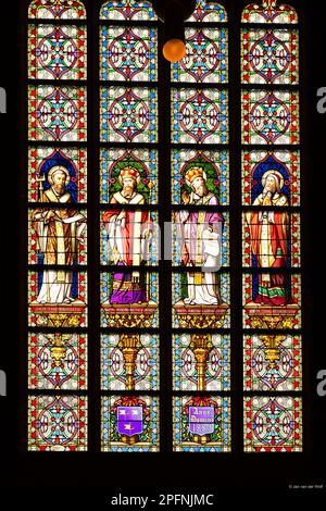 Vetrata colorata raffigurante un santo che esegue il sacramento della Santa Comunione in San John's Cathedral, a den Bosch, Paesi Bassi. Foto Stock