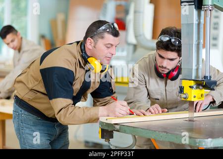 due falegnami in officina per la misurazione del legno da segare Foto Stock