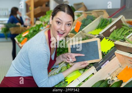 tavola holding del venditore di frutta e verdura femminile Foto Stock